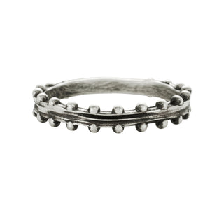 A Karen Karch sterling silver band with a weathered texture center and repeating ball details on both sides on a white background.