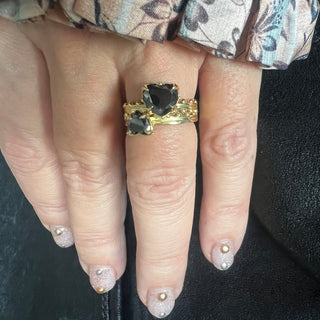 Karen Karch Jaipur Swing and Sway heart-shaped black diamonds 2-ring set in gold with intricate metalwork and ball details on a hand.