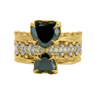 A three-ring stack with the top and bottom rings featuring heart-shaped black diamonds in gold settings, and the center ring with diamond-studded half-eternity in 18kw on white background.