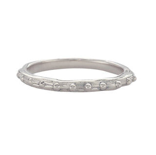 A Karen Karch platinum band with a textured surface and ball embellishments along the circumference on a white background.