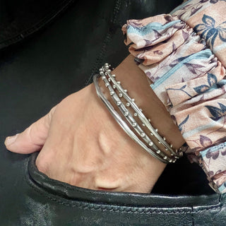 Karen Karch weathered Silver Oval Shape Jaipur Serene bangle stacked with Jaipur Evermore and Jaipur Swing bangles on wrist.