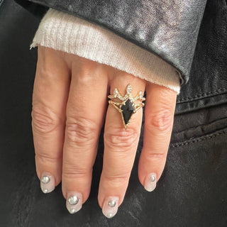 Karen Karch by Deme Wolfe diamond-shaped black onyx gemstone set in a chiseled 14k yellow gold band ring stacked on a hand