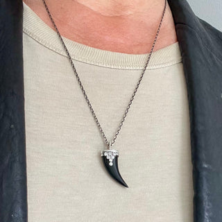 Karen Karch Draped Lucky Horn Amulet in Silver with Diamonds and Black Onyx on Chain on person in leather jacket