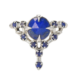 A Karen Karch silver cocktail ring featuring a large round lapis center stone surrounded by smaller lapis stones, in a star-like formation on a white background.