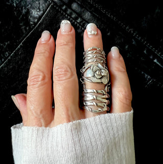 Karen Karch Gabrielle Rose silver knuckle ring with a rosebud that sits over the knuckle that connects to two Gladiator Vine Bands extending the length of the finger on the finger.
