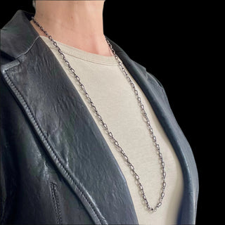 A person wearing a Karen Karch Jaipur Infinite sterling silver handmade link chain necklace with a length of 32.5 inches.