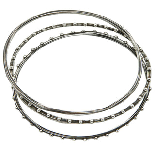Set of 3 unique oval shape silver bangles by Karen Karch top view on white background.