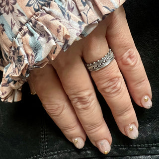 A Karen Karch Jaipur Swing and Sway Sterling Silver 2-Ring Stack with a textured center and repeating ball details on a hand.