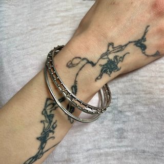 Set of 3 unique oval shape silver bangles by Karen Karch on a wrist