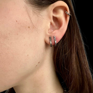 Karen Karch  pair of silver post bar earrings with a weathered look paired together on an ear
