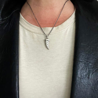 Karen Karch Rapt Horn in textured Sterling Silver on chain on pefrson in leather jacket