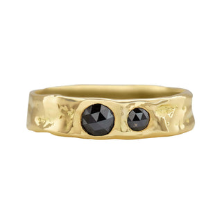 A Karen Karch 18k Gold unisex band ring with two rose-cut black diamonds of different sizes sunken into the surface on a white background.