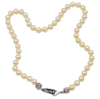 A pearl choker necklace with a black diamond silver clasp and handmade cube silver beads.