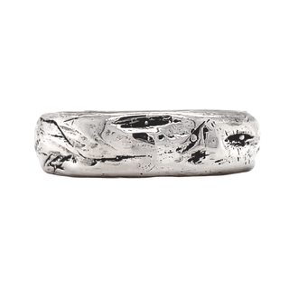 A Karen Karch silver domed weathered band with an irregular rounded edge on a white background.