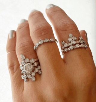Karen Karch Platinum and Diamond Rings styled on hand on white backround.