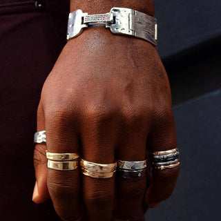 Karen Karch Styled Unisex Mixed Metal Rings stacked on every finger of a hand with a wide silver bracelet with a diamond clasp on the wrist.
