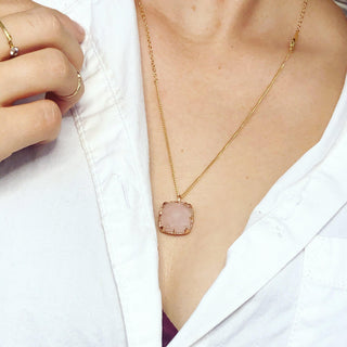 Karen Karch by Deme Wolfe Pink rose quartz pendant with gold frame with sharp claws on a chain on a person