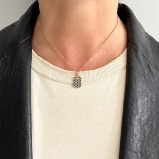 Karen Karch 10ky Blue Sapphire Studdded xs dog tag on a chain on a person. 