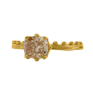 An 18k yellow gold ring by Karen Karch with a cushion-cut champagne diamond set in a four-claw demi-bezel setting, featuring a weathered texture band with ball details on a white background.