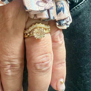 An 18k yellow gold ring by Karen Karch with a cushion-cut champagne diamond set in a four-claw demi-bezel setting, featuring a weathered texture band with ball details on hand stacked with a half eternity band.