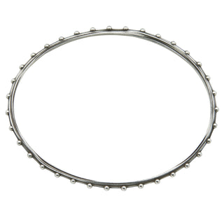 A Karen Karch oval shape silver bangle bracelet with a repeated ball detail along the edge, top view, displayed on a white backround.