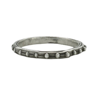 A Karen Karch sterling silver band with a textured surface and ball embellishments along the circumference on a white background.