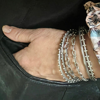 Karen Karch Jaipur inspired styled silver bangles and chains on wrist.