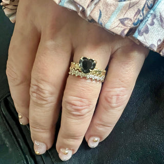 KAREN KARCH Jaipur Swing Heart Solitaire black diamond 18ky ring with a four-claw demi-bezel and a textured ball detail gold band stacked with an 18kw Diamond Half Eternity on hand.
