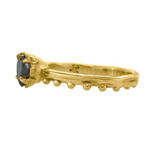 KAREN KARCH Jaipur Sway Heart Solitaire black diamond 18ky ring with a four-claw demi-bezel and a textured ball detail gold band, side view, on white background.