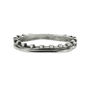 A Karen Karch sterling silver band with a weathered texture center and repeating ball details on one side on a white background.