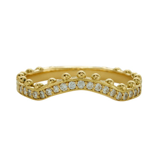 A curved, yellow gold band by Karen Karch with a row of ball details on one side, studded with colorless diamonds half way.