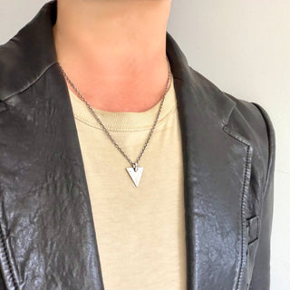 Karen Karch Silver weathered triangle tag pendant on a neck.