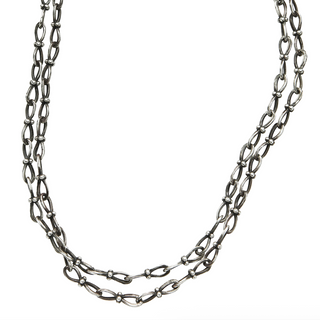 A person wearing a Karen Karch Jaipur Infinite sterling silver handmade link chain necklace with a length of 32.5 inches doubled, close up on white bacground.