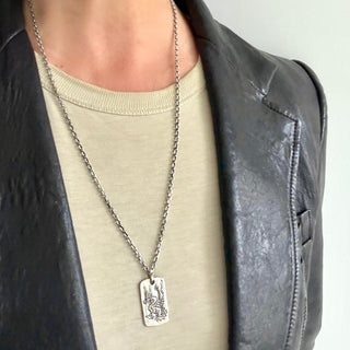 Karen Karch Silver Dragon Legend Tag with Vine Bail on chain on  a person