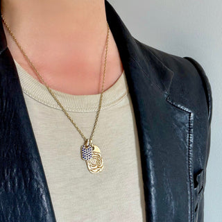 aren Karch Rose Tattoo Dog Tag in 10k Yellow Gold layered with a Blue Sapphire Studded smaller tag on Chain on model in black leather jacket.