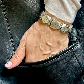 Karen Karch Silver Outshine 16mm wide bracelet with geometric square faceted corner links on a wrist.