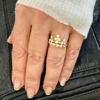 Karen Karch 18k Yellow Gold bezel set Colorless Diamond Ring configured in the shape of a tiara for the finger stacked with a 6 diamond Grace Band on a hand.