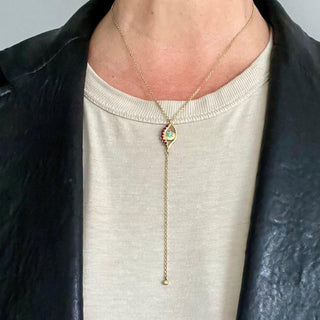 Karen Karch 18k yellow gold Evil Eye Centerpiece Lariat Chain Necklace Ruby Eyelashed and Turquoise center close up on a person
