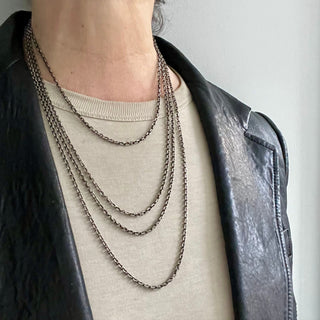 Karen Karch oxidized silver diamond-cut cable chain necklaces in various lengths on a person close up.