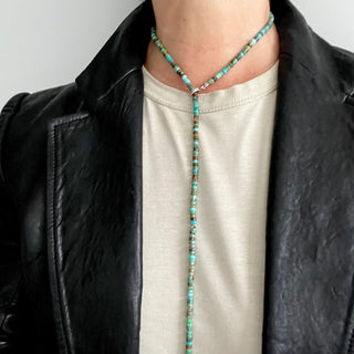 A multi-colored turquoise and silver heishi bead lariat with a weathered texture closure by Karen Karch modeled