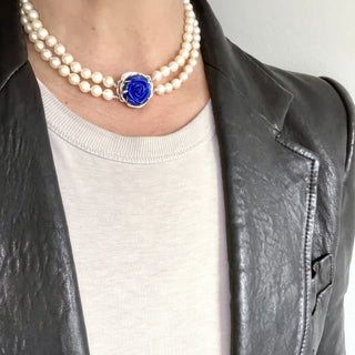 Karen Karch custom carved lapis rose centerpiece clasp on double strand of pearls on a person's neck.