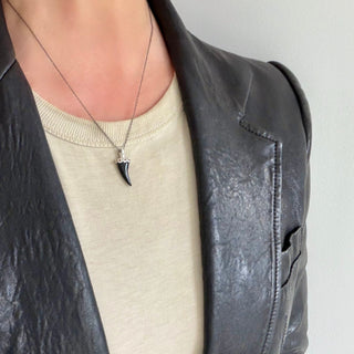 Karen Karch Sterling Silver Pink Sapphire Dotted Lucky Horn Black Onyx on a chain on a neck.