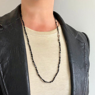 Karen Karch Epitome 3mm Black Spinel Faceted Disk Bead Necklace shown on a person with a t-shirt and leather jacket. 