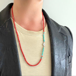 Karen Karch Epitome Coral accented with Turquoise Beaded Necklace shown on a person with a t-shirt and leather jacket. 