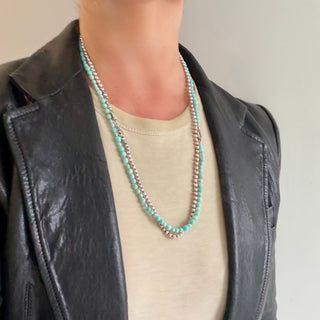 Karen Karch Epitome 3mm Pink Freshwater Pearl Necklace shown layered with turquoise beads on a person with a t-shirt and leather jacket. 