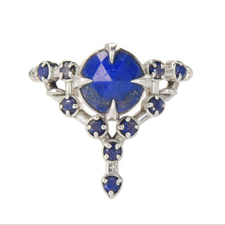 A Karen Karch silver cocktail ring featuring a large round lapis center stone surrounded by smaller lapis stones, in a star-like formation on a white background.