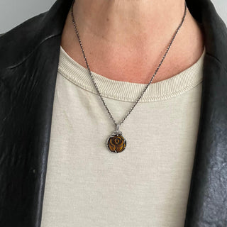 Karen Karch Silver carved Tiger's Eye Rosebud Charm set in silver on a silver chain on a person.