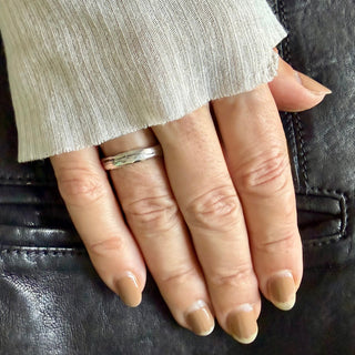 Karen Karch Gleam 4mm Weathered Silver Domed Band on a hand.