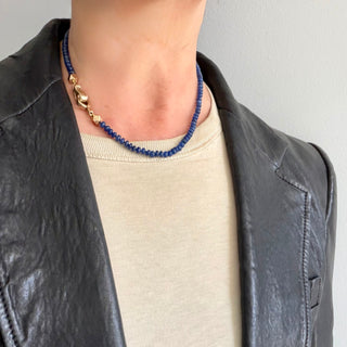 A Karen Karch Blue Sapphire beaded necklace with a 10k yellow gold weathered clasp on a neck with the clasp worn toward the side.  