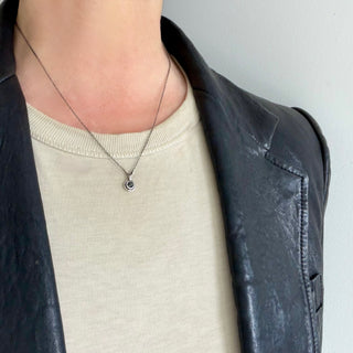 Karen Karch Inner Circe Silver 4mm Rose Cut Black Diamond Charm on a chain on a person.